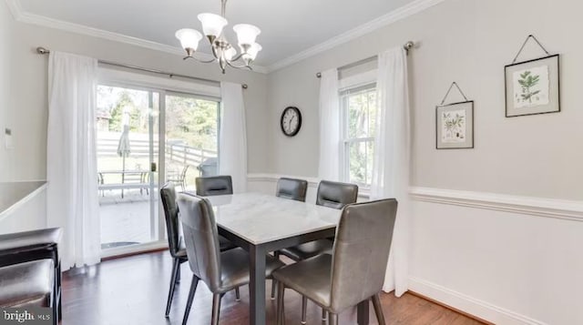 dining area featuring an inviting chandelier, hardwood / wood-style flooring, and ornamental molding