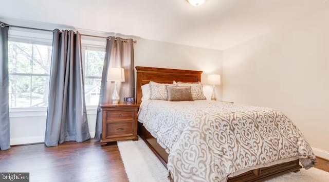 bedroom featuring multiple windows and dark hardwood / wood-style floors