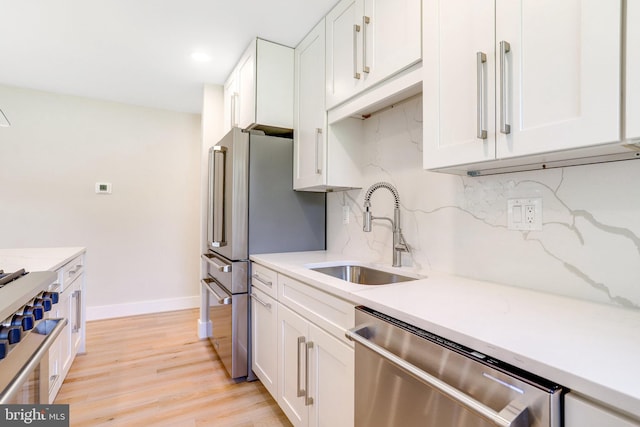 kitchen featuring tasteful backsplash, appliances with stainless steel finishes, sink, and white cabinets