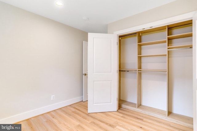 unfurnished bedroom featuring wood-type flooring and a closet