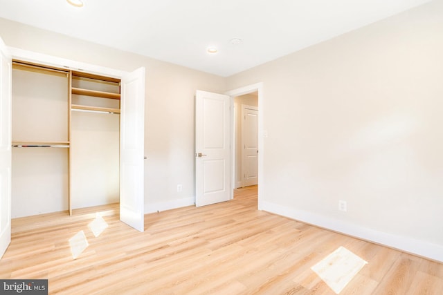 unfurnished bedroom with a closet and light hardwood / wood-style flooring