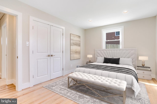 bedroom with light hardwood / wood-style floors and a closet