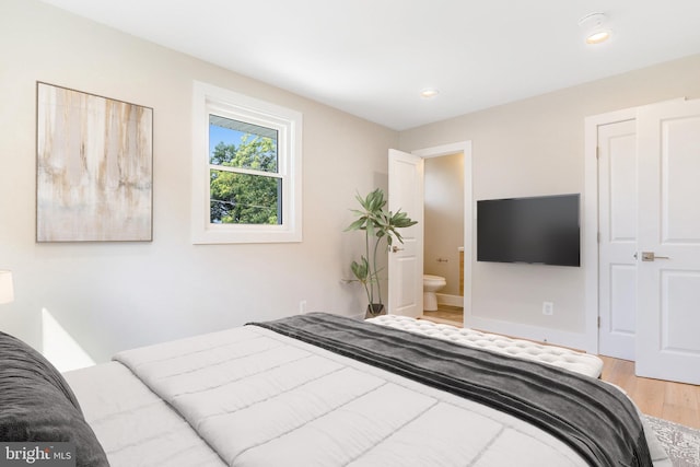 bedroom with wood-type flooring and ensuite bathroom