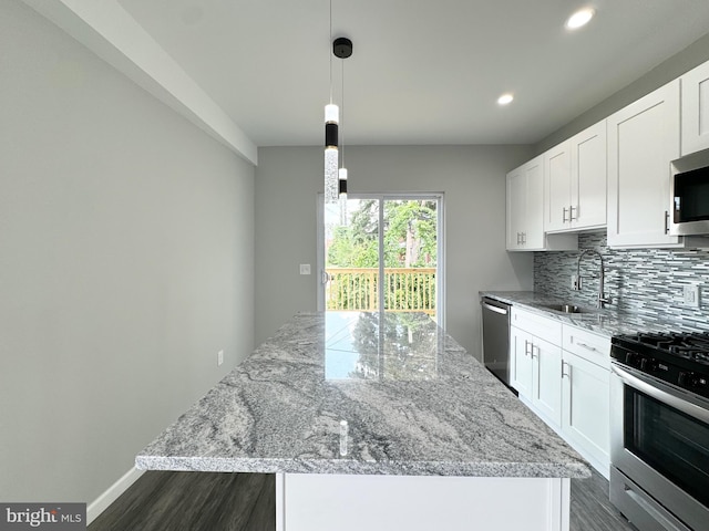 kitchen with tasteful backsplash, stainless steel appliances, sink, a kitchen island, and dark hardwood / wood-style floors