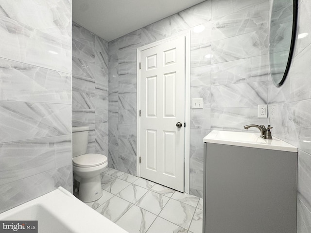 full bathroom with vanity, tile patterned floors, toilet, and tile walls