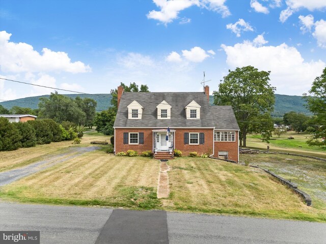 new england style home featuring a garage and a front yard