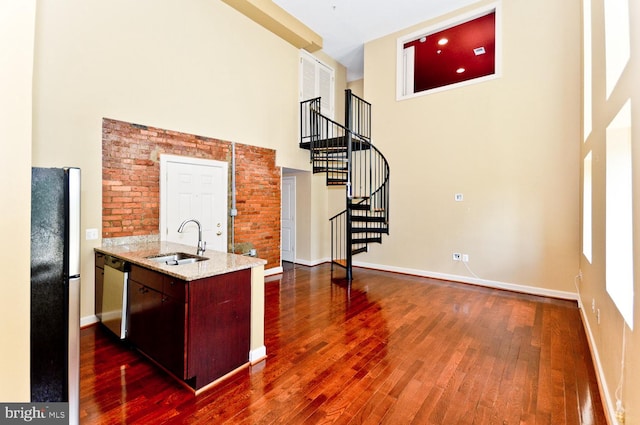 kitchen with stainless steel appliances, a high ceiling, dark hardwood / wood-style floors, and sink