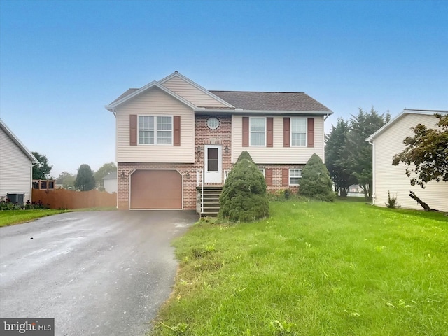 split foyer home with a front lawn, central air condition unit, and a garage