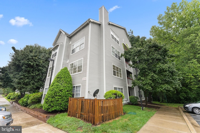 exterior space featuring a lawn and a balcony