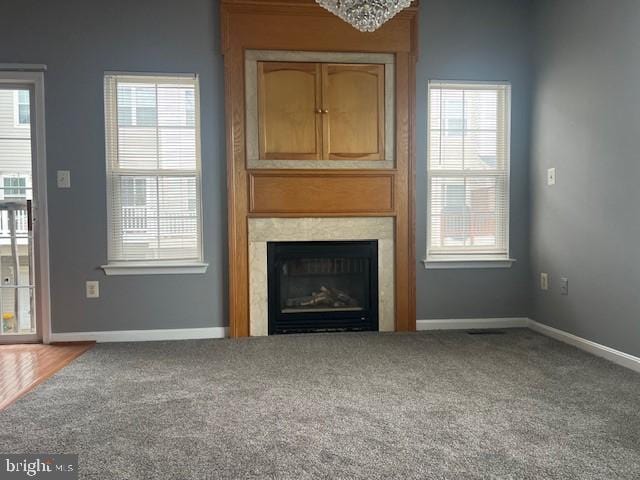 unfurnished living room with plenty of natural light and carpet