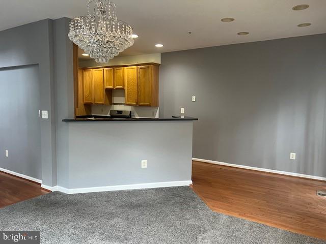 kitchen featuring dark hardwood / wood-style flooring, an inviting chandelier, and hanging light fixtures