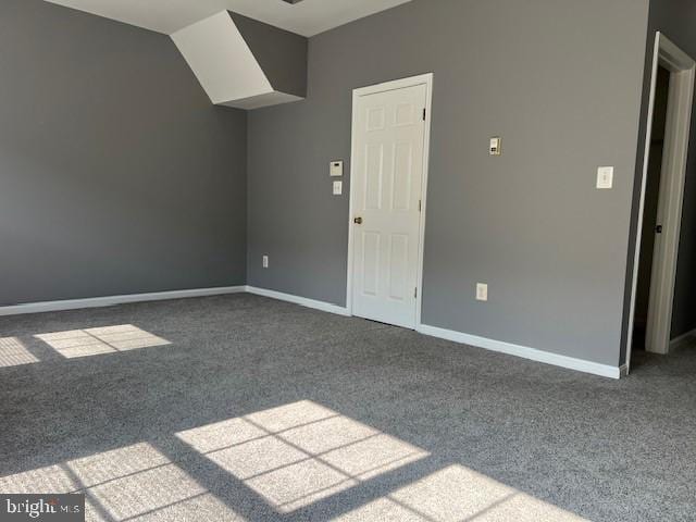 unfurnished room featuring lofted ceiling and carpet