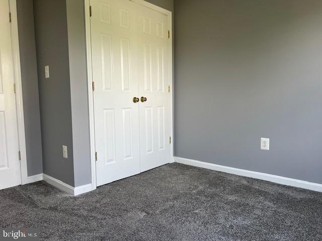 unfurnished bedroom with carpet and a closet