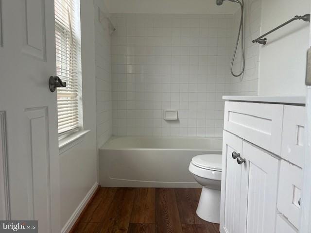 full bathroom featuring tiled shower / bath combo, vanity, toilet, and hardwood / wood-style floors