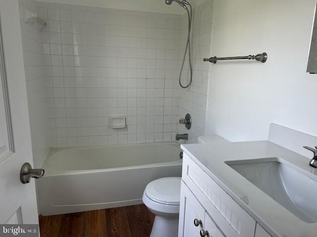 full bathroom featuring toilet, wood-type flooring, and tiled shower / bath