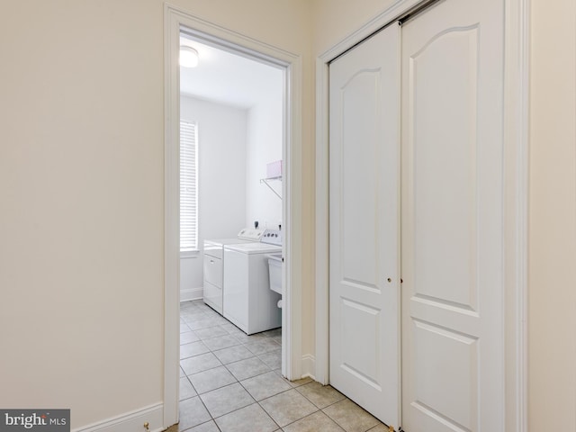 corridor featuring light tile patterned floors and washer and dryer