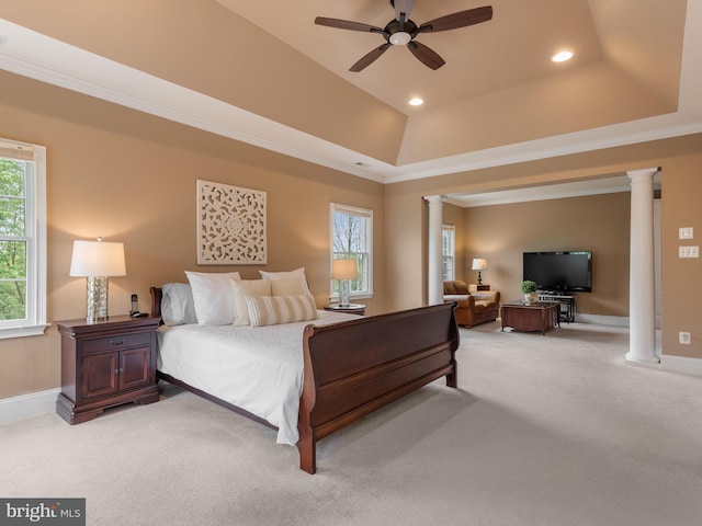 carpeted bedroom with decorative columns, a raised ceiling, ornamental molding, and ceiling fan