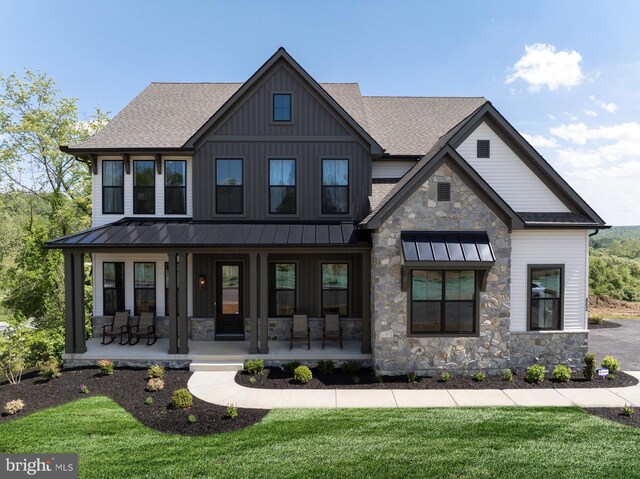 view of front of house with covered porch and a front lawn