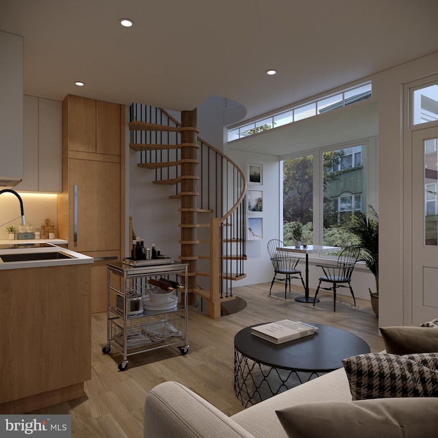 living room featuring sink and light hardwood / wood-style floors