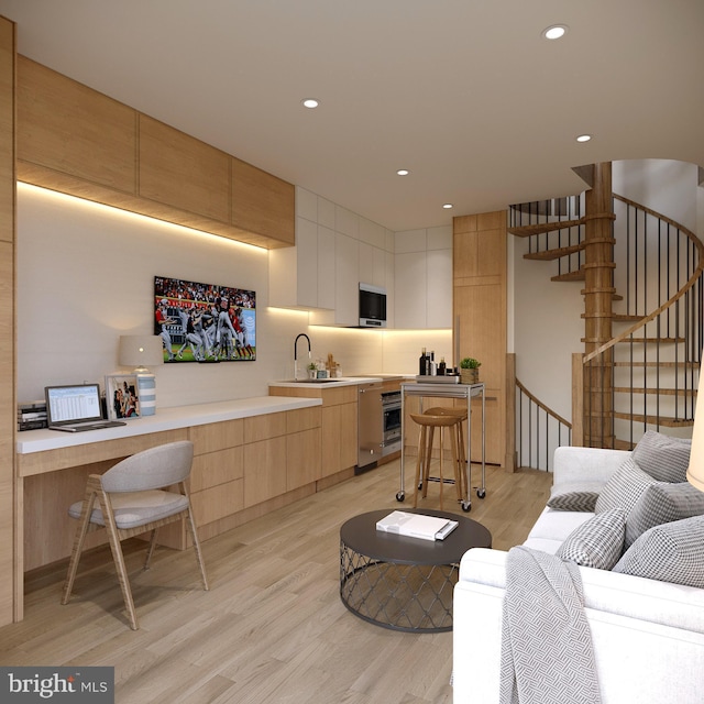 living room featuring sink and light hardwood / wood-style floors