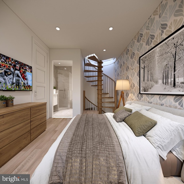 bedroom with ensuite bathroom and light wood-type flooring