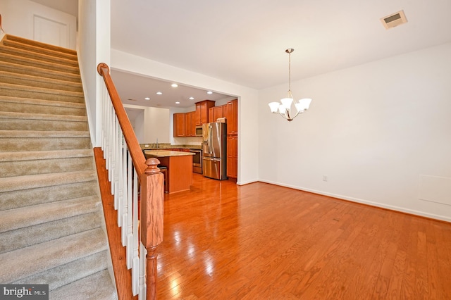 interior space with an inviting chandelier and light hardwood / wood-style floors