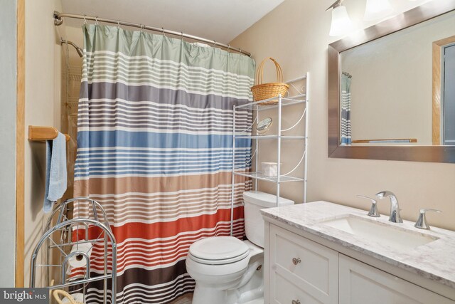 bathroom with a shower with curtain, vanity, and toilet