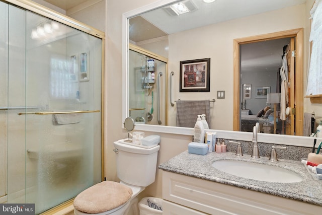 bathroom featuring vanity, toilet, and an enclosed shower