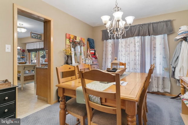 tiled dining area featuring a chandelier