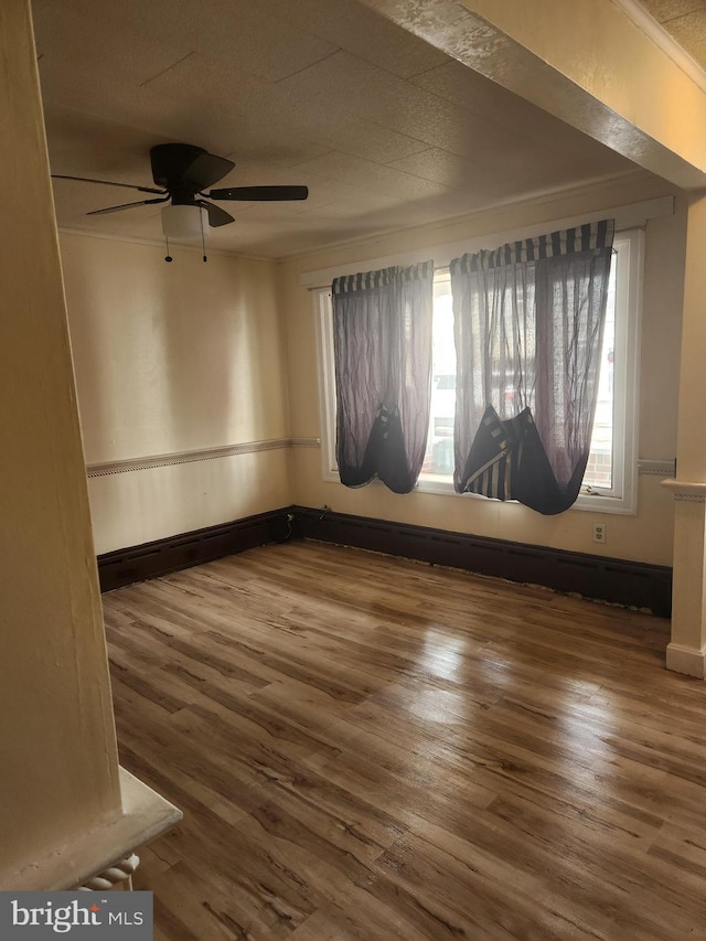 empty room featuring ornamental molding, hardwood / wood-style flooring, and ceiling fan