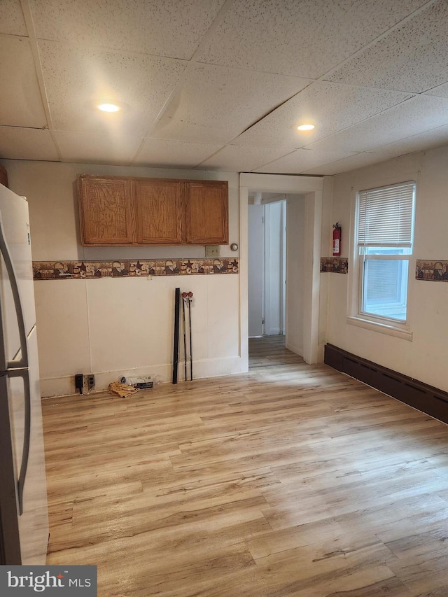 kitchen featuring refrigerator, light hardwood / wood-style floors, and a paneled ceiling