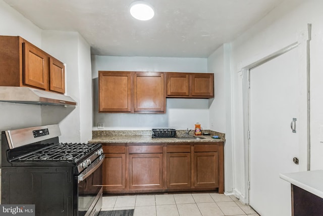 kitchen with sink, light tile patterned floors, and gas range