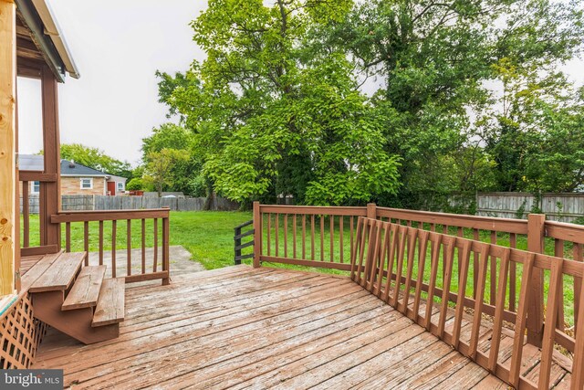 wooden deck featuring a lawn