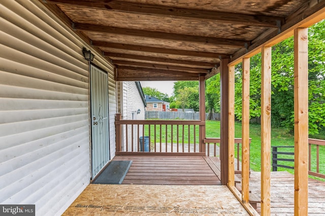 wooden deck featuring a lawn