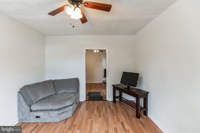 sitting room with light wood-type flooring and ceiling fan