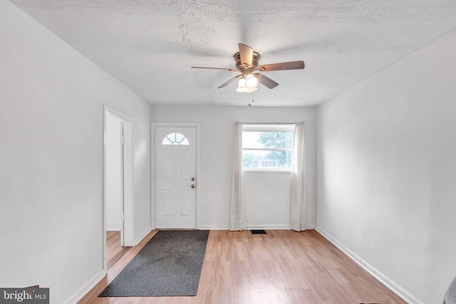 foyer entrance featuring light hardwood / wood-style floors, a textured ceiling, and ceiling fan