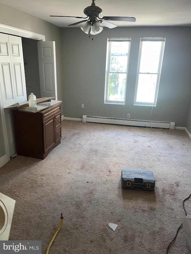 interior space featuring ceiling fan, a baseboard heating unit, and light colored carpet