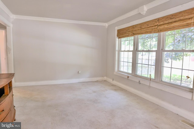 spare room with carpet floors, baseboards, visible vents, and ornamental molding