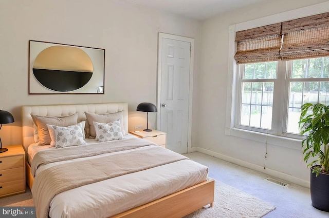 bedroom featuring light carpet, baseboards, and visible vents