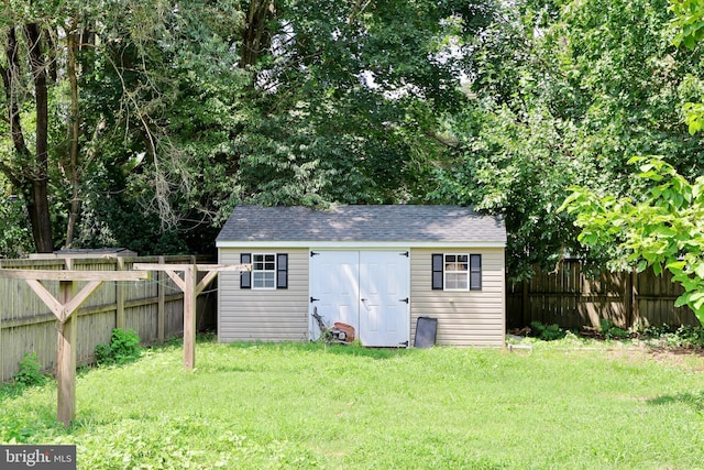 back of property featuring a lawn and a storage unit