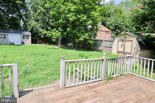 wooden terrace featuring a lawn and a storage unit