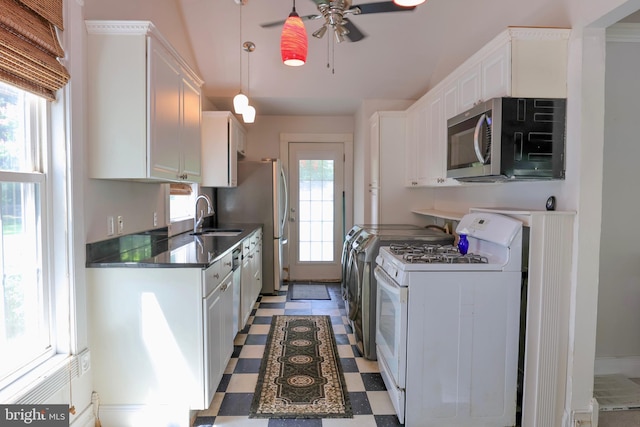 kitchen featuring tile patterned floors, white cabinetry, white gas range, stainless steel microwave, and dark countertops