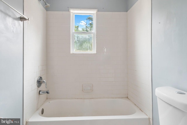 bathroom featuring tiled shower / bath and toilet