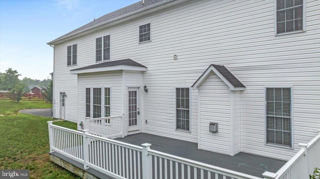 back of house featuring a lawn and a deck