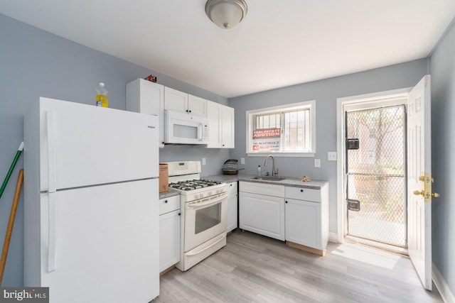 kitchen featuring white cabinetry, sink, white appliances, and light wood-type flooring