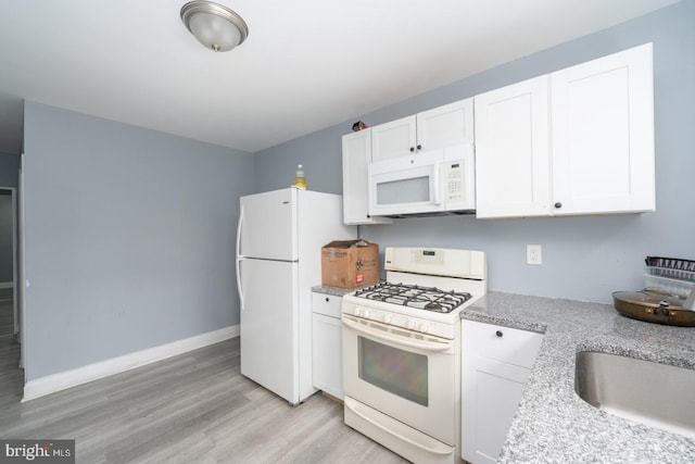 kitchen featuring white cabinetry, white appliances, light hardwood / wood-style flooring, and light stone countertops