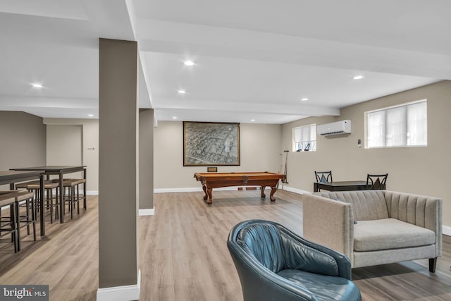 game room with billiards, light wood-type flooring, and a wall mounted air conditioner