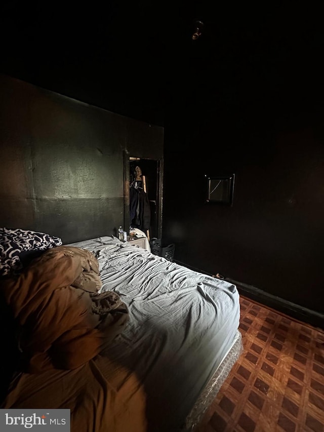 bedroom featuring dark floors and baseboards