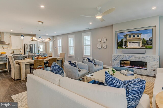 kitchen featuring sink, hanging light fixtures, wood-type flooring, and an island with sink