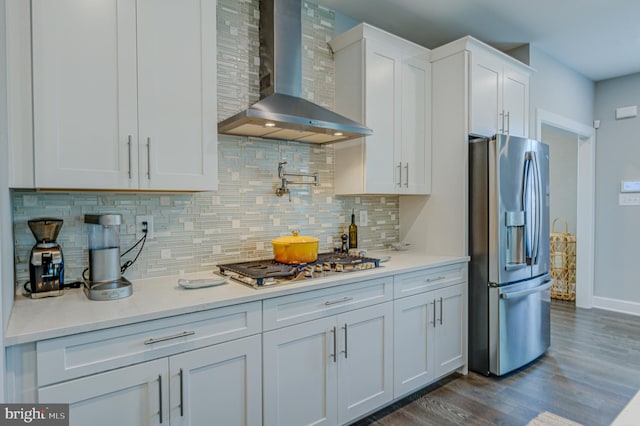 kitchen with wall chimney exhaust hood, white cabinetry, stainless steel appliances, and dark hardwood / wood-style floors